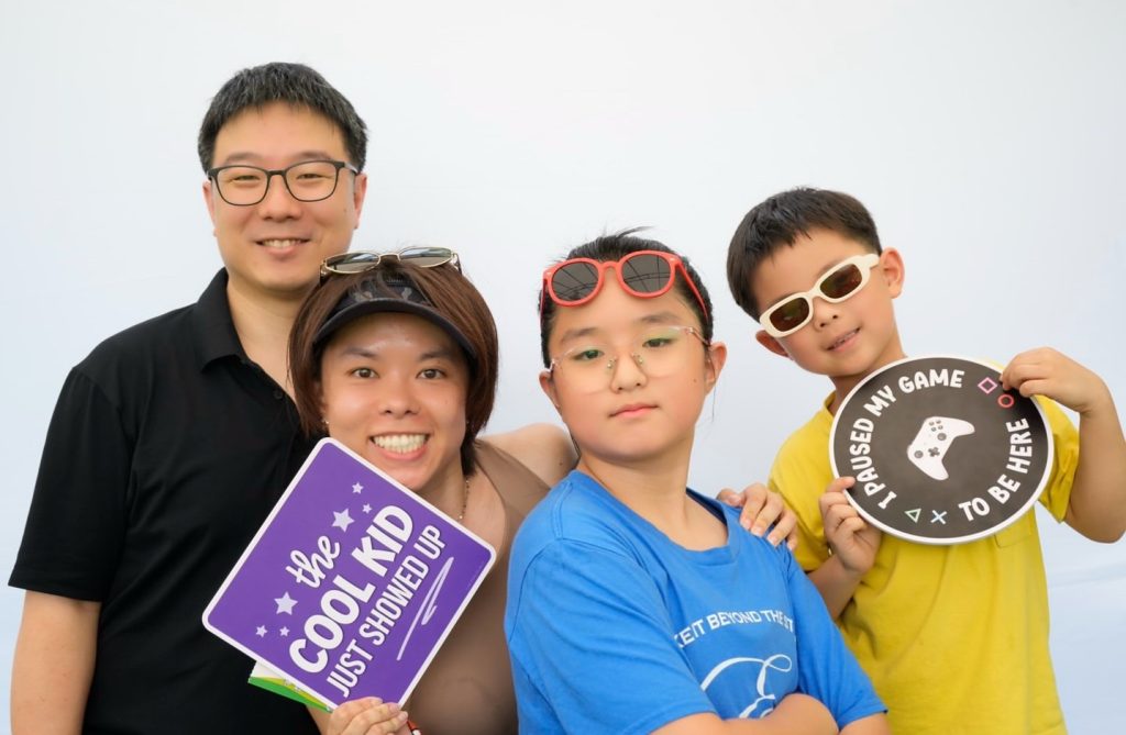 A family posing together at the HappiSwitch photobooth at a Singapore charity event
