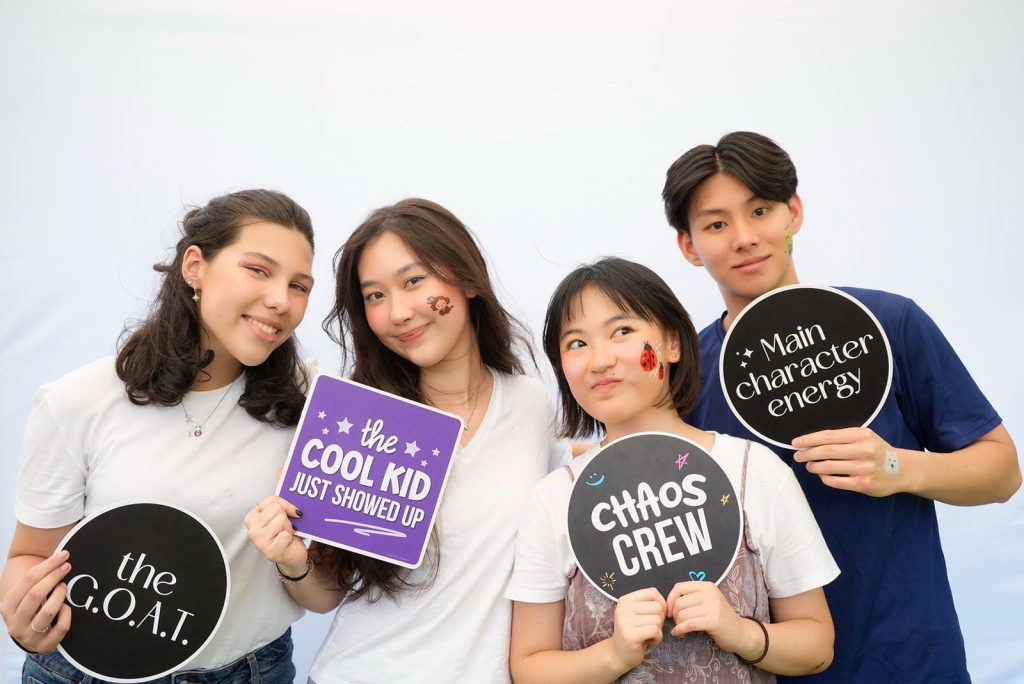 Teenagers with props at the HappiSwitch photobooth at a Singapore charity walk
